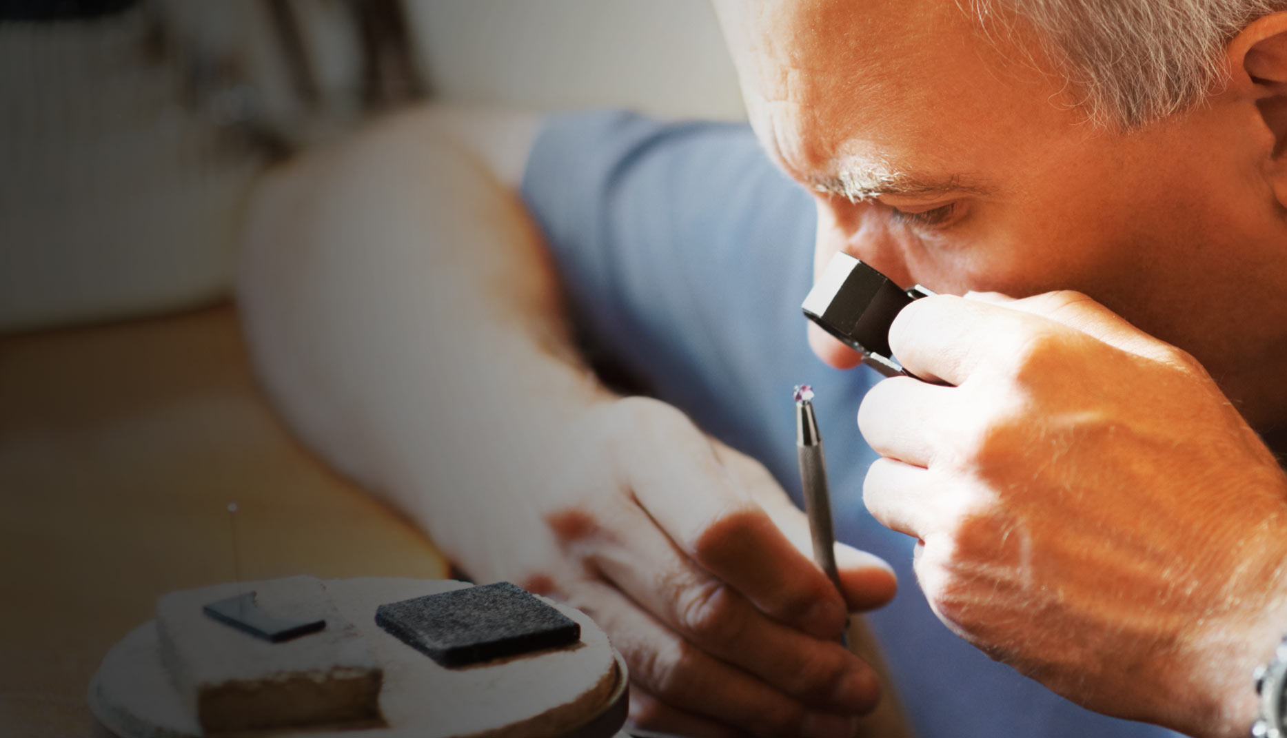 Gemologist using a gem loupe to examine pink spinel